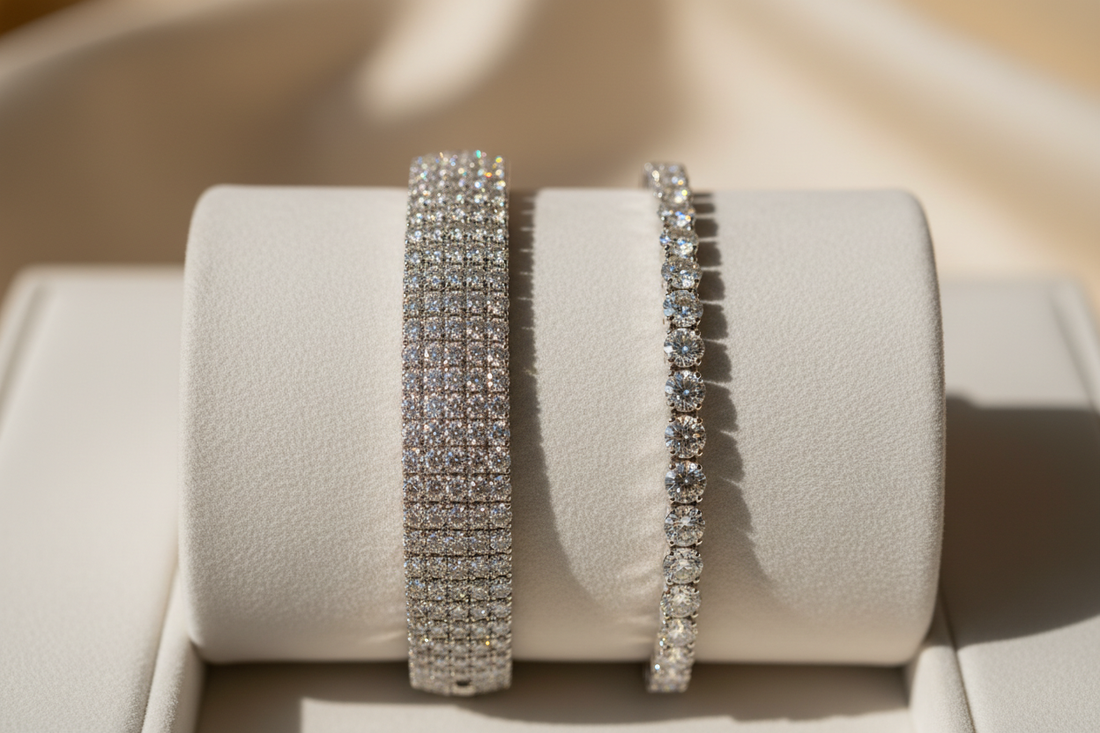 Pavé diamond bracelet and tennis bracelet resting side by side on a white velvet jewelry tray in soft warm studio light.