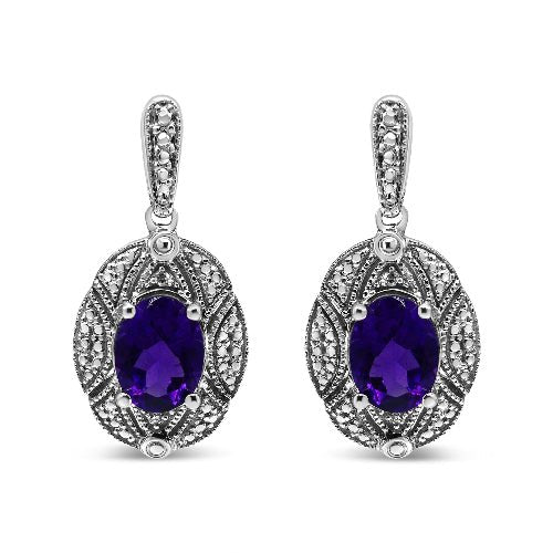 Pair of silver earrings with purple gemstones on a white background