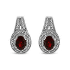 Pair of silver earrings with red gemstones on a white background