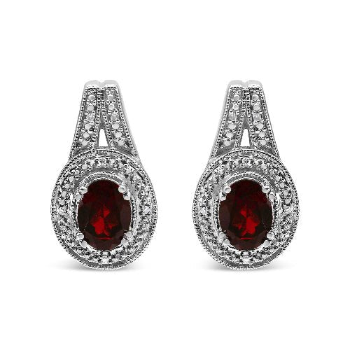 Pair of silver earrings with red gemstones on a white background