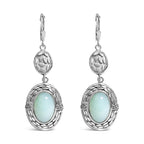Silver earrings with light blue gemstones on a white background