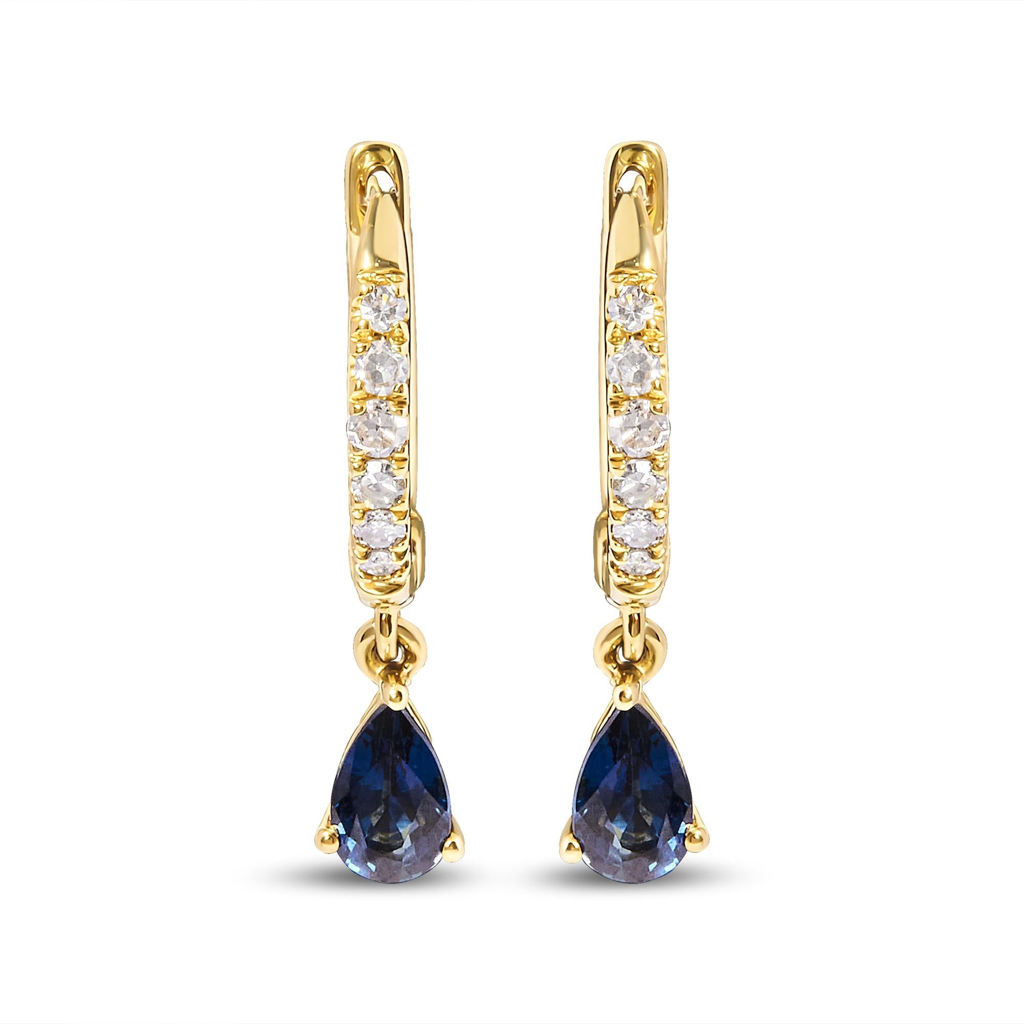 Gold earrings with blue teardrop gemstones on a white background