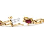 Gold and silver bracelet with a red gemstone on a white background