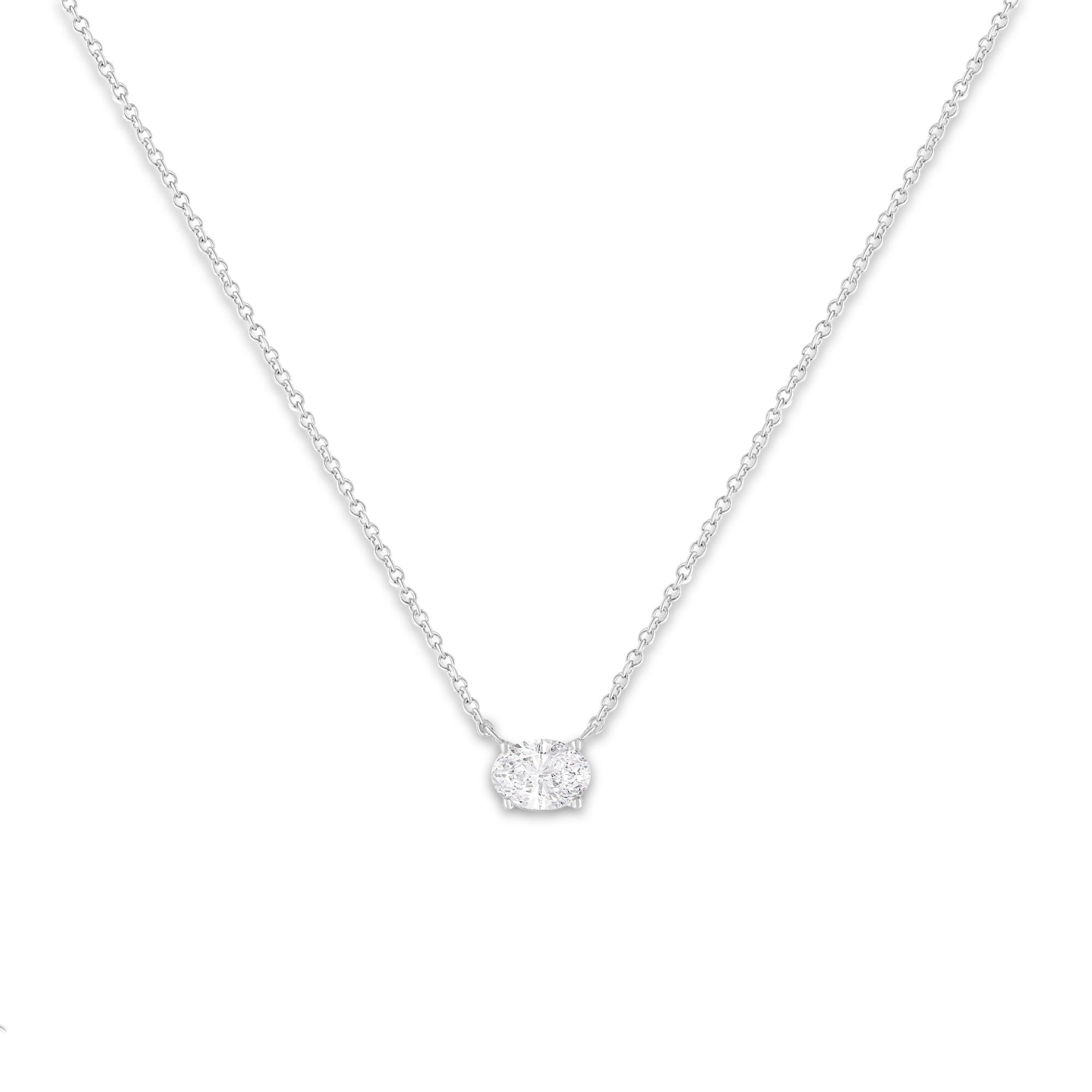 Silver necklace with a small round pendant on a white background