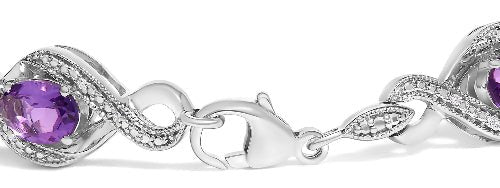 Silver bracelet with purple gemstones on a white background