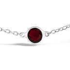 Silver bracelet with a red gemstone on a white background