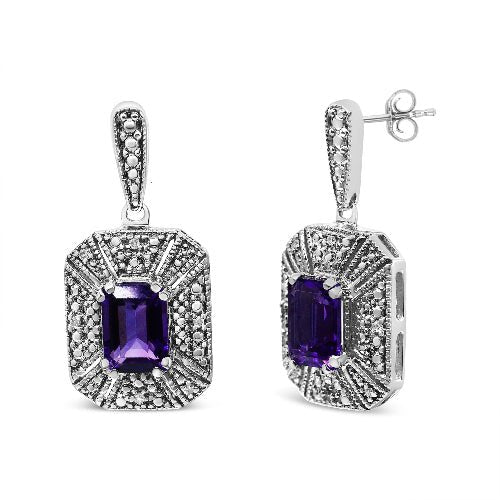 Pair of silver earrings with purple gemstones on a white background