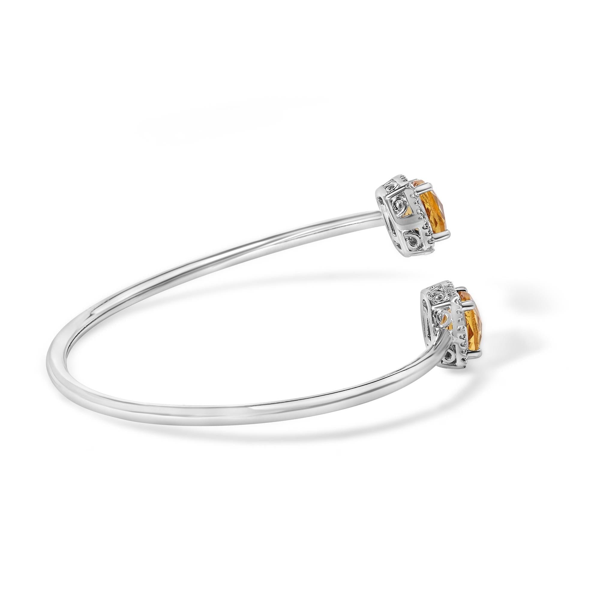 Silver bangle with orange gemstones on a white background