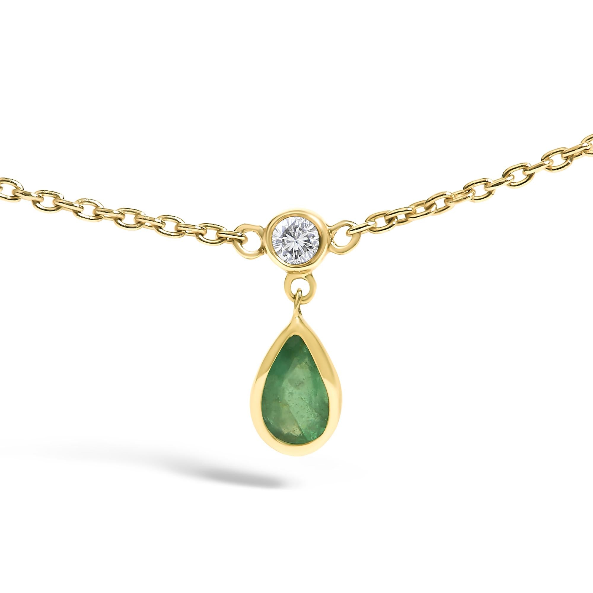 Gold necklace with a teardrop-shaped green gemstone pendant on a white background
