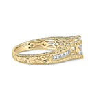 Gold ring with intricate design and diamond accents on a white background