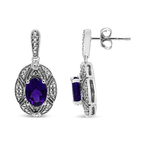 Pair of silver earrings with purple gemstones on a white background