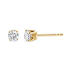Gold stud earrings with clear gemstones on a white background