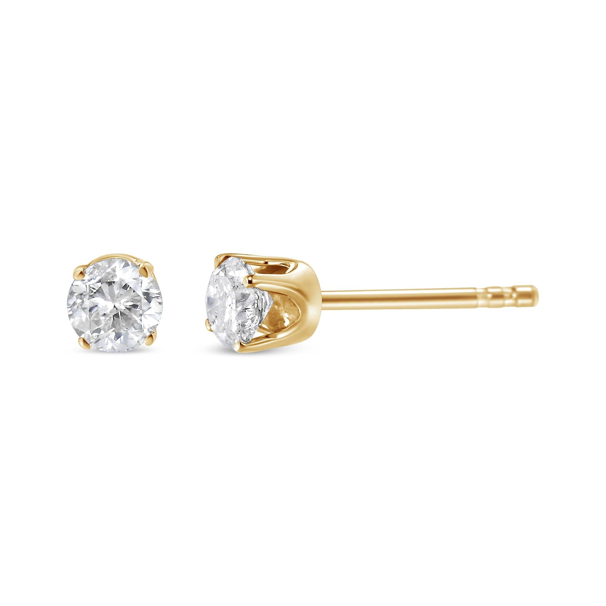 Gold stud earrings with clear gemstones on a white background