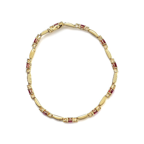 Gold bracelet with embedded red stones on a white background