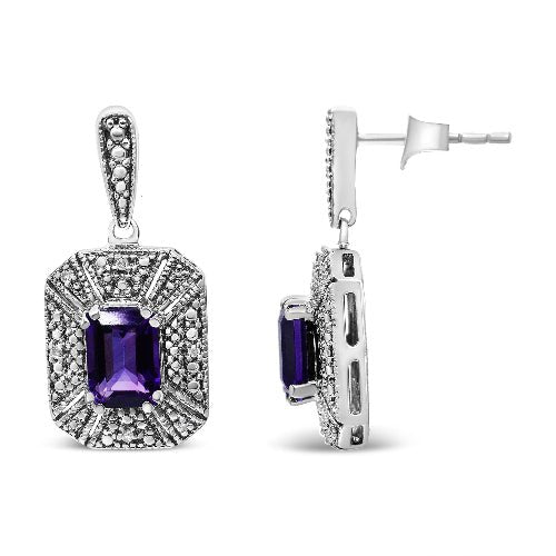 Pair of silver earrings with purple gemstones on a white background