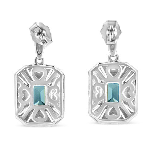 Pair of silver earrings with blue gemstones on a white background