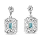 Pair of silver earrings with blue gemstones on a white background