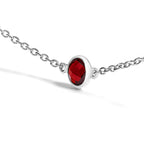 Silver necklace with a red gemstone on a white background