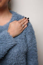 Person wearing a blue fluffy sweater with a neutral background