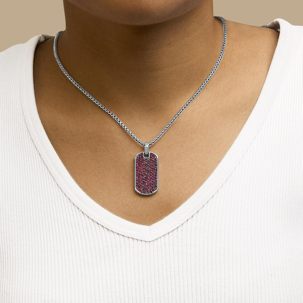 Necklace with a red pendant worn by a person on a beige background