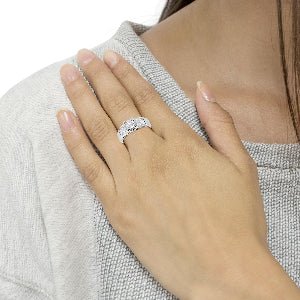 Close-up of a hand wearing a diamond ring on a neutral background