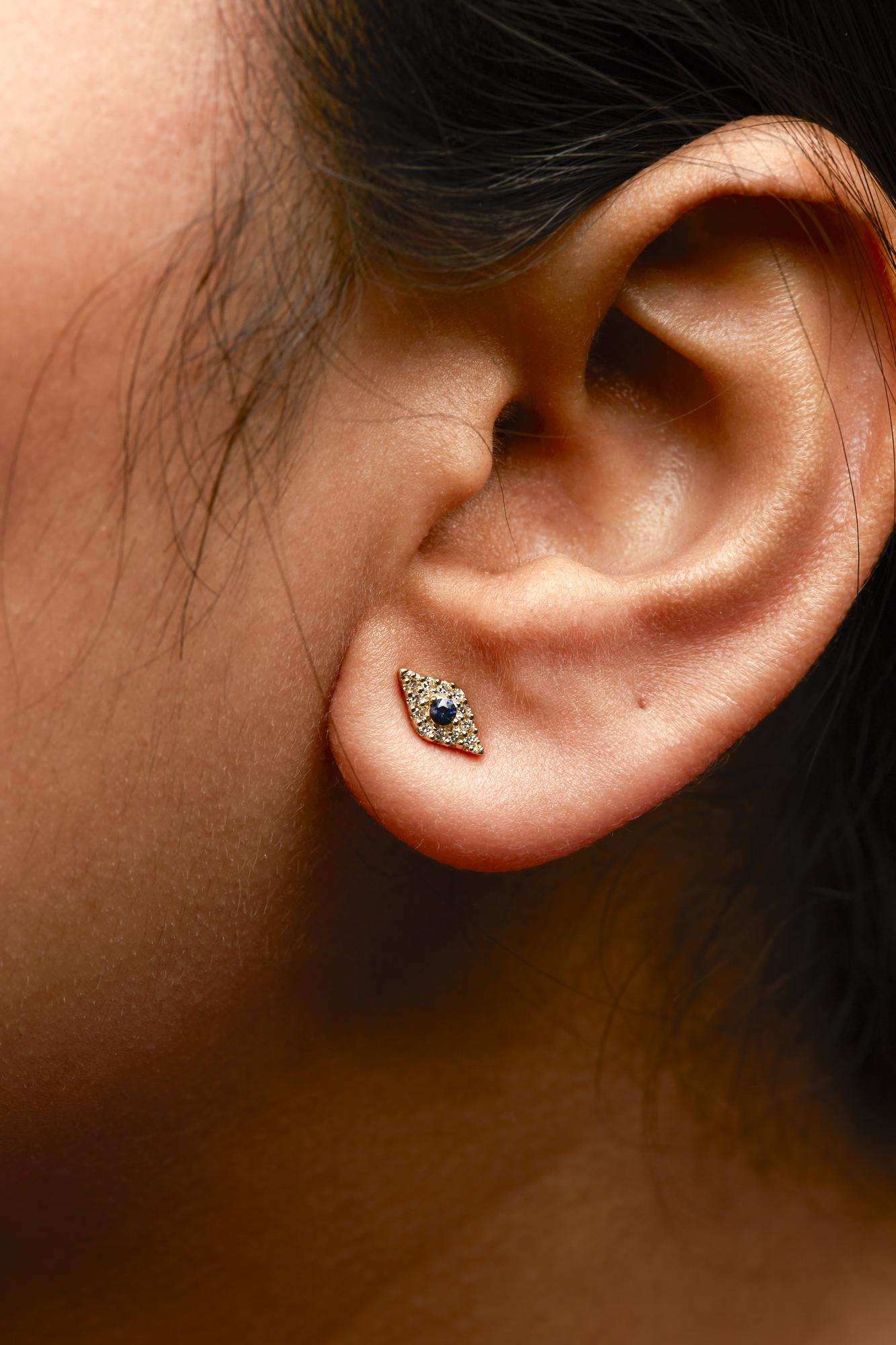 Close-up of an ear wearing a decorative earring with a blurred background