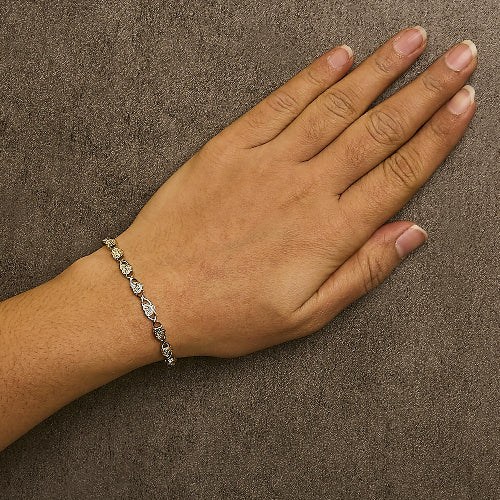 Hand wearing a bracelet on a brown textured background