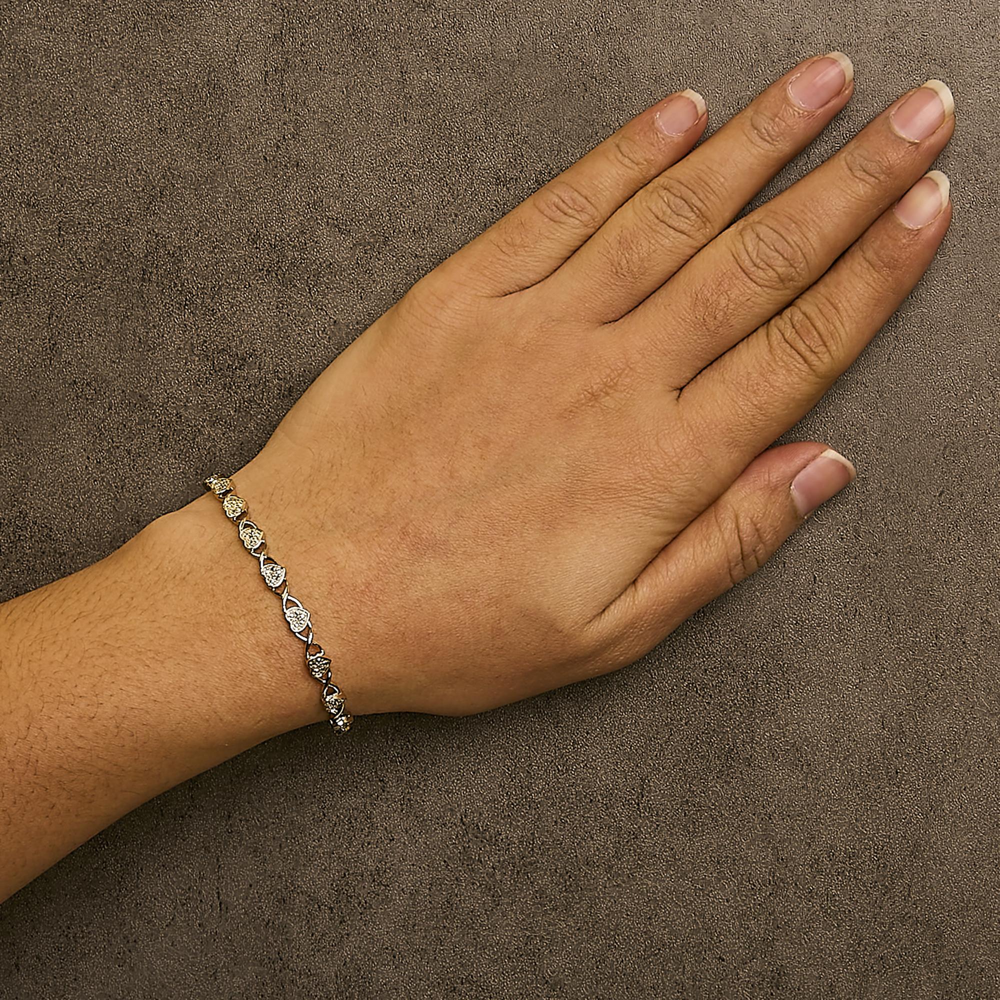 Hand wearing a bracelet on a brown textured background