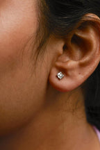 Close-up of an ear wearing a diamond stud earring.