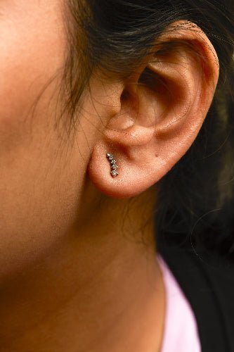 Close-up of an ear with earrings on a blurred background