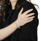 Person wearing a gold bracelet on a black background
