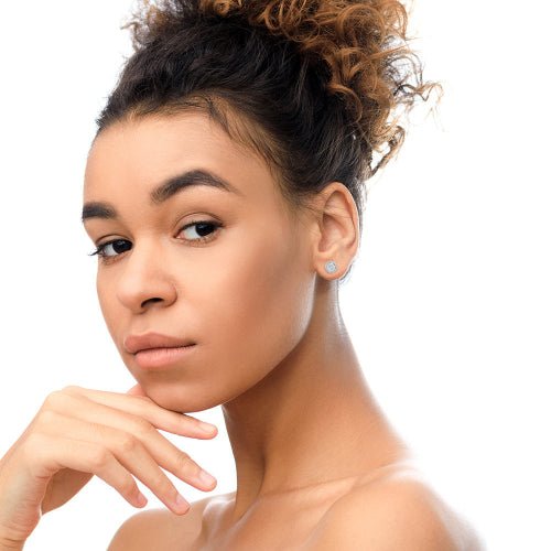 Woman with styled hair and hoop earrings on a white background