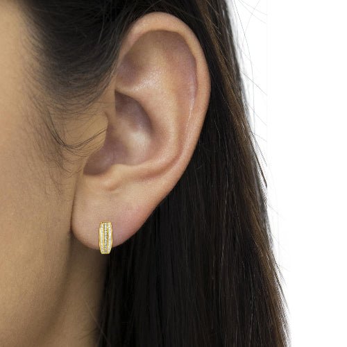 Gold hoop earring worn by a person with dark hair.