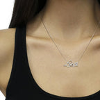Necklace with 'Love' pendant on a person wearing a black top