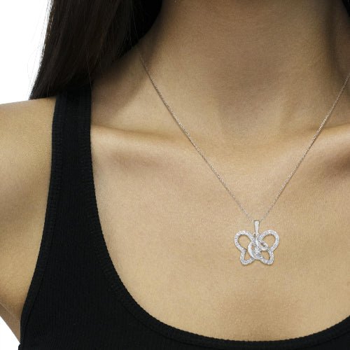 Necklace with a gold and silver pendant on a person wearing a black top.