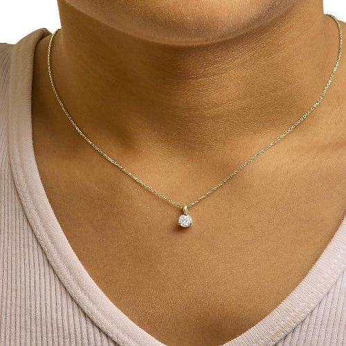 Gold necklace with a diamond pendant on a mannequin