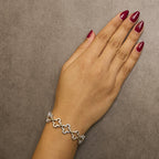 Hand wearing a silver bracelet on a brown background