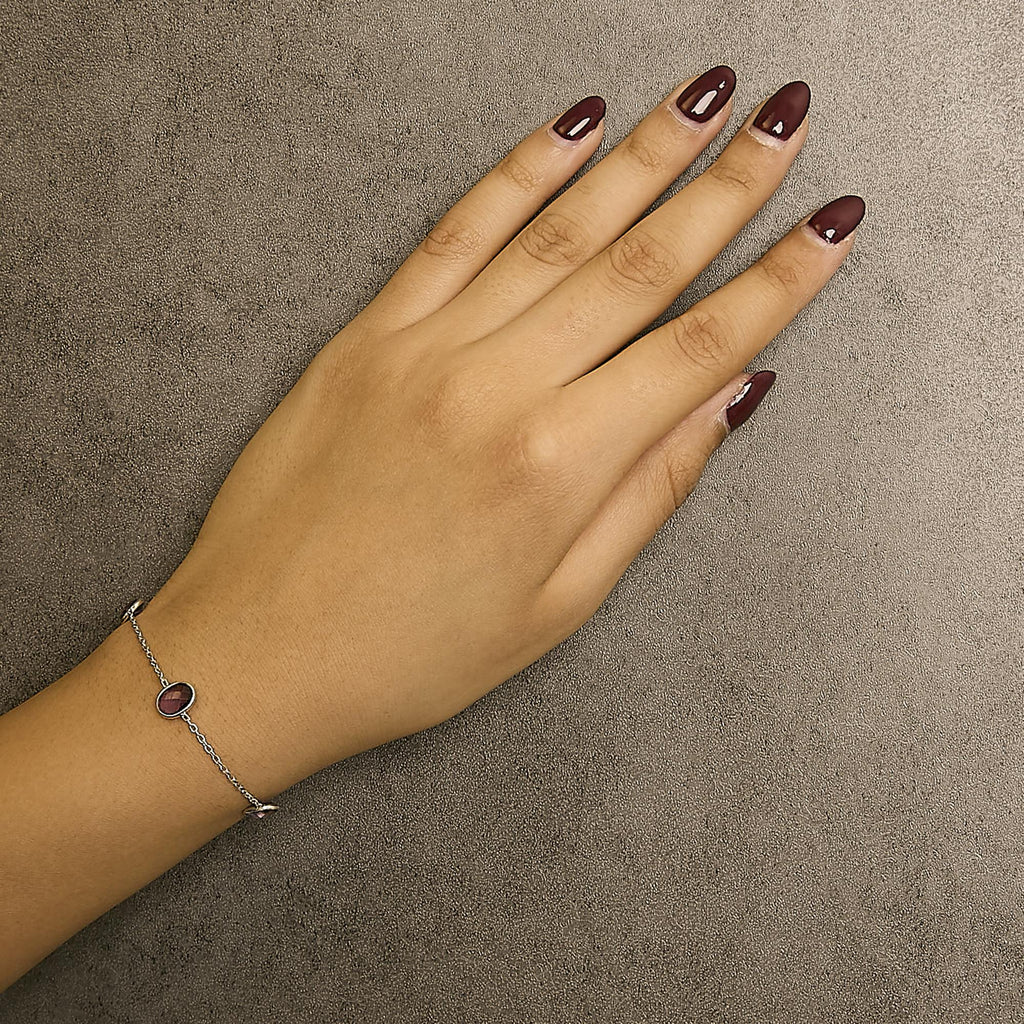 Hand with a silver bracelet on a brown background