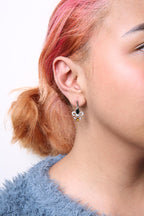 Close-up of a person wearing an earring with a white background
