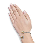 Silver bracelet with yellow gemstones on a hand against a white background