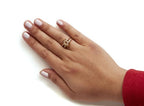 Hand wearing a gold ring on a white background