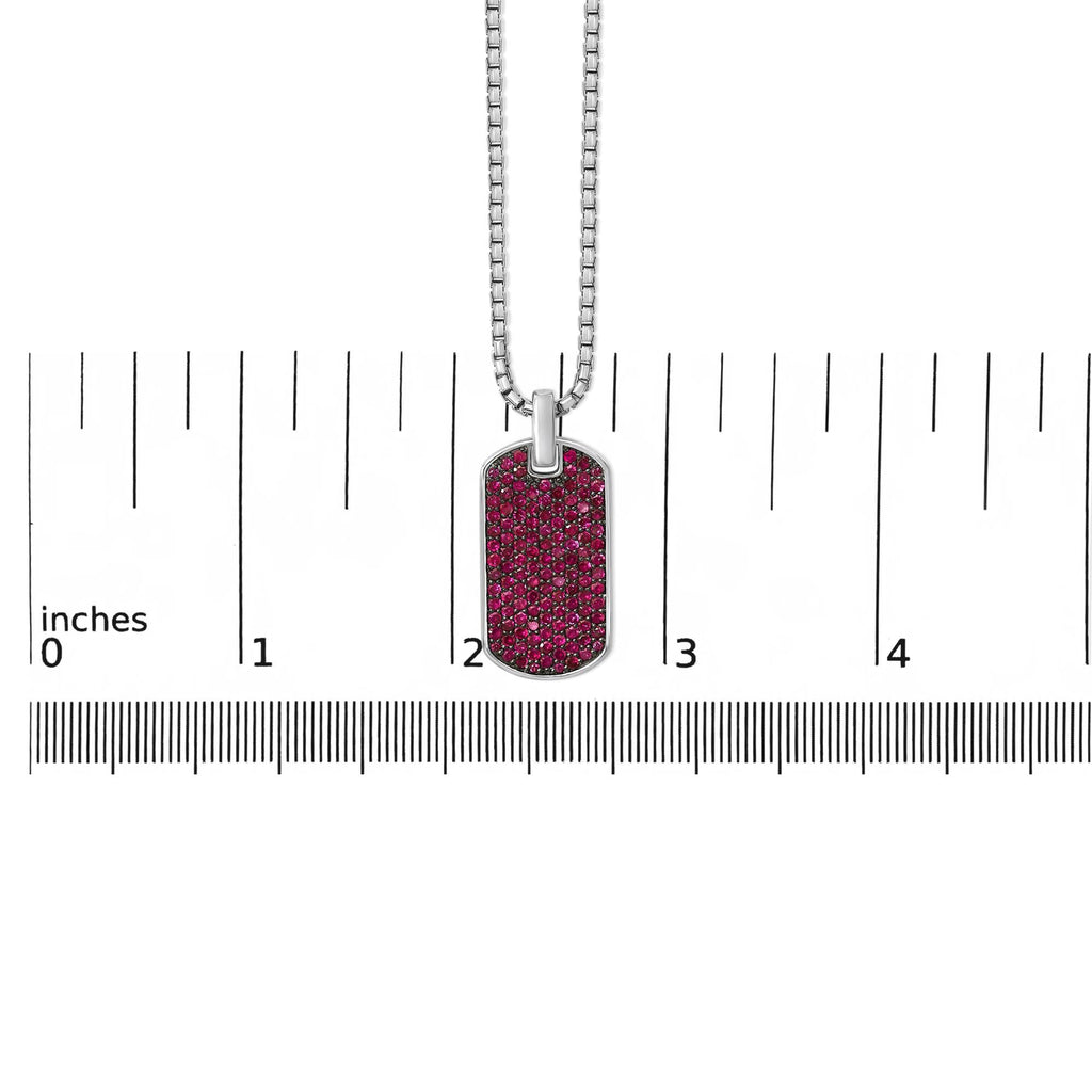 Dog tag pendant with pink glittery design on a chain, shown with a ruler for scale.