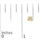 Gold four-leaf clover pendant on a measurement scale