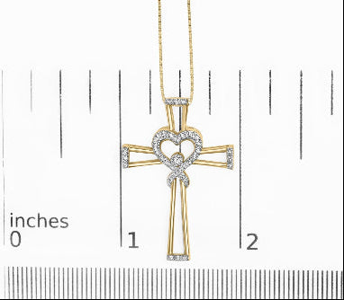 Gold cross necklace with heart detail on a measurement scale