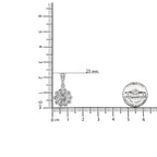 Silver pendant with floral design next to a ruler for scale on a white background