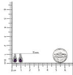 Pair of earrings with purple gemstones next to a ruler for scale on a white background.