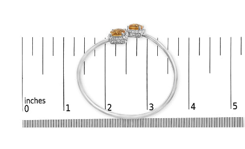 Silver bracelet with orange gemstones on a white background with measurement scale