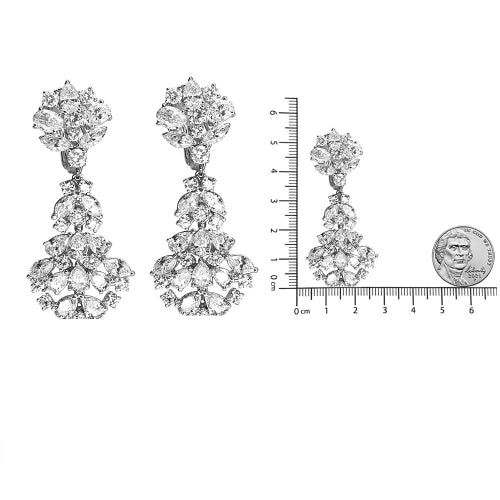 Pair of diamond earrings with a ruler for scale on a white background