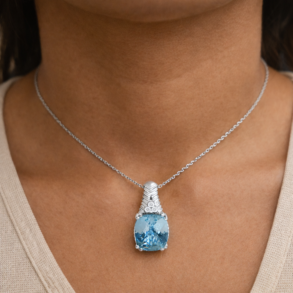 Necklace with a blue gemstone pendant on a person wearing a beige top.