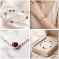 Silver bracelet with red gemstones on a white background, worn on a wrist, and displayed in a box.